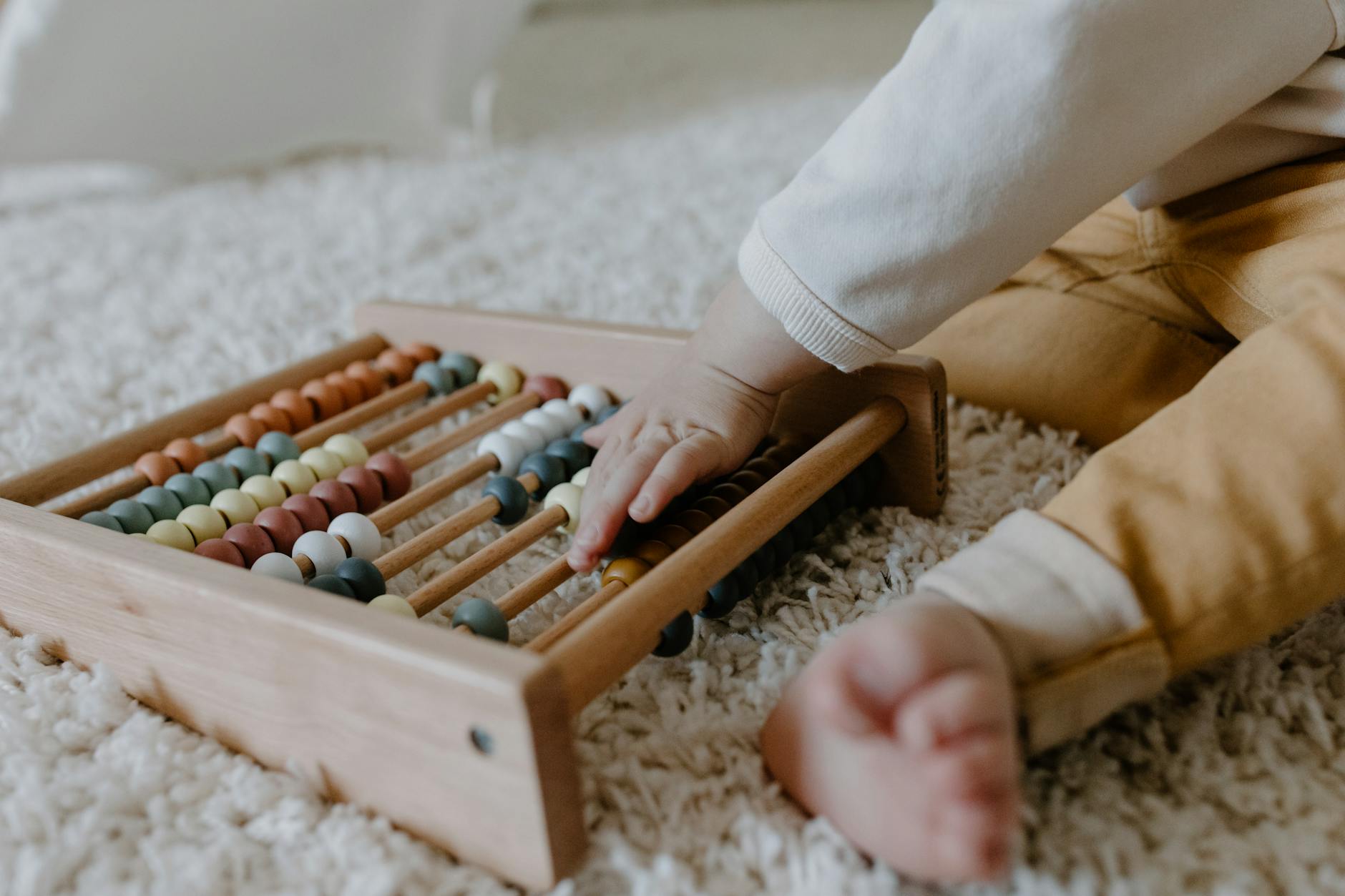 a toddler holding a wooden toy